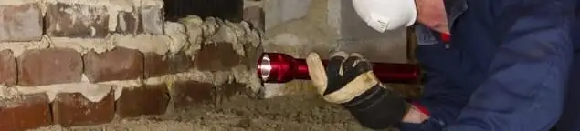 Pest control technician inspecting a crawl space for ant activity and entry points in Boca Raton, FL