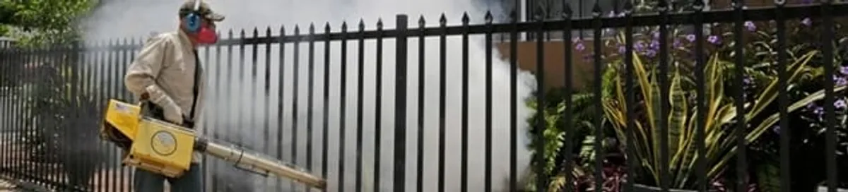 Mosquito control technician fogging a yard perimeter for mosquito reduction in Boca Raton, FL
